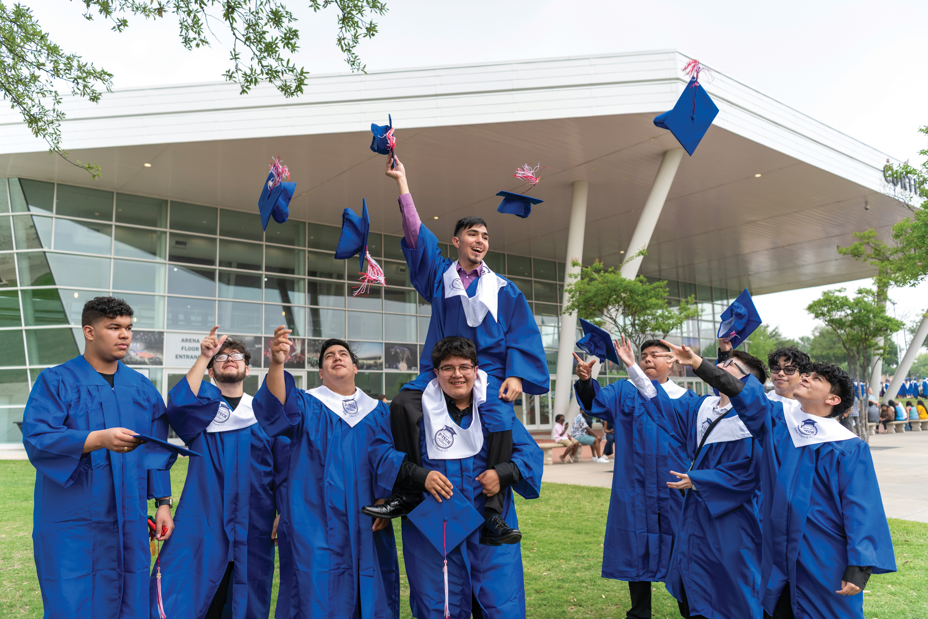 Group of Dallas College graduates celebrating and throwing their caps