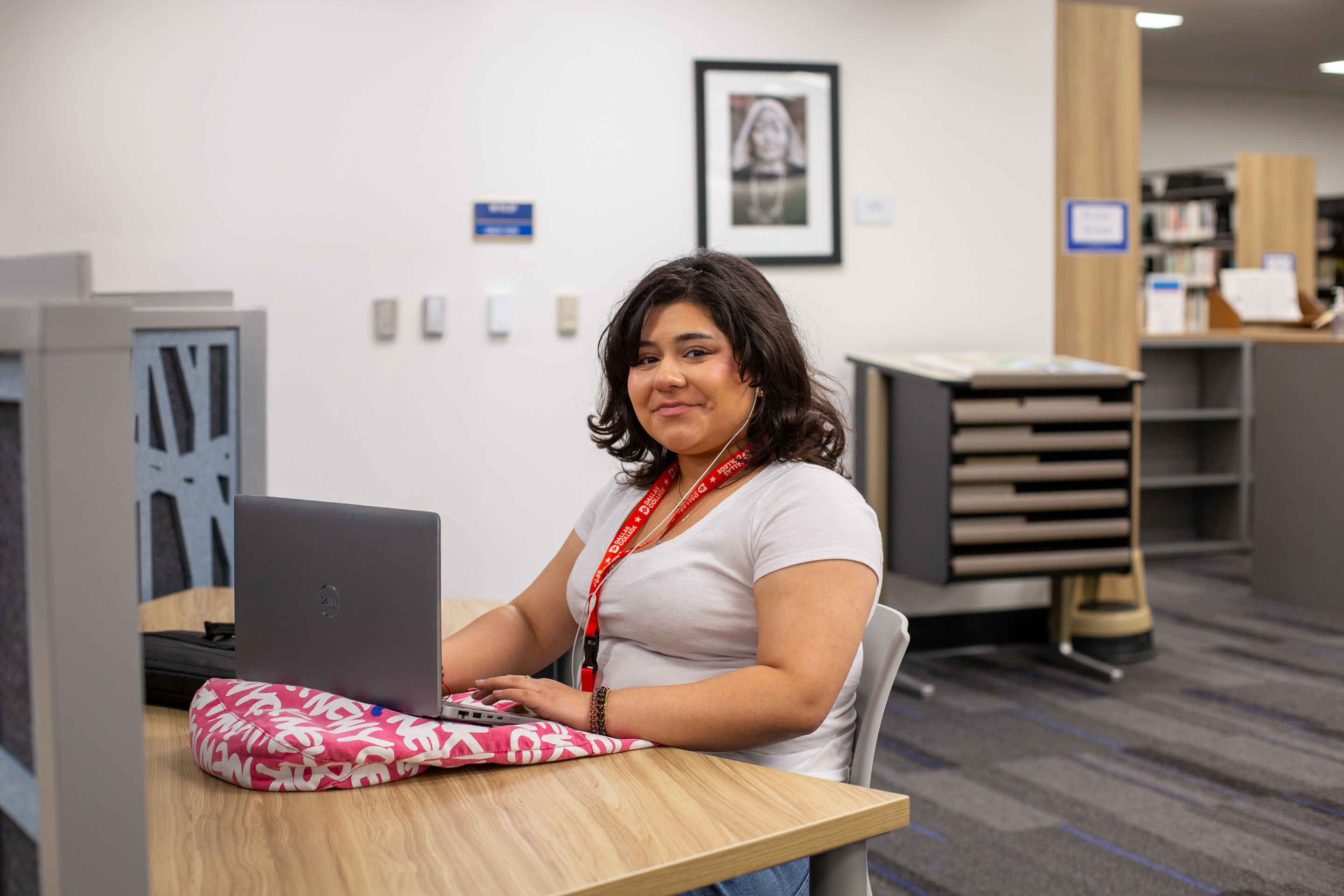 Student in library smiling at camera