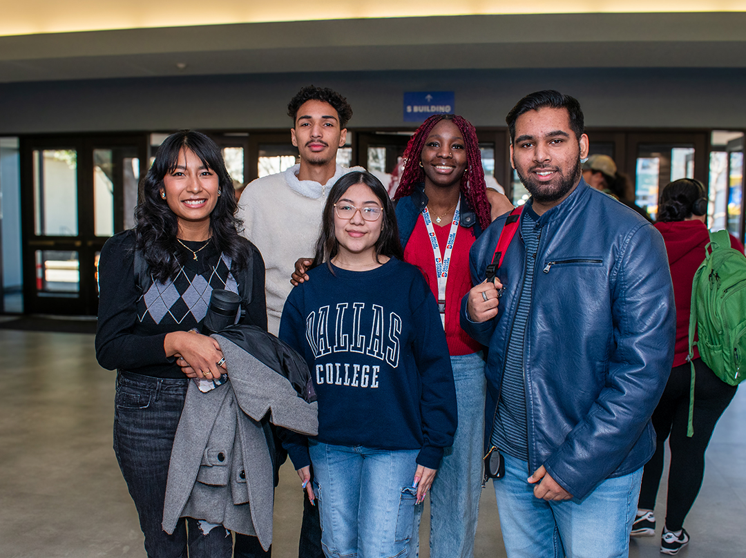 Group of students standing next to each other on a Dallas College campus smiling at the camera